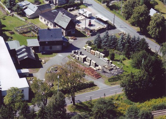 Luftbild des Betriebsgeländes von Holz-Eberth in Bärenstein mit Werkstatt, Lagerplatz und gestapeltem Holz.