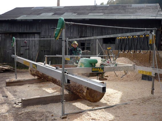 Das mobile Lucas-Mill-Sägewerk von Holz-Eberth beim Zuschnitt eines Stammes vor der alten Holzscheune in Bärenstein.