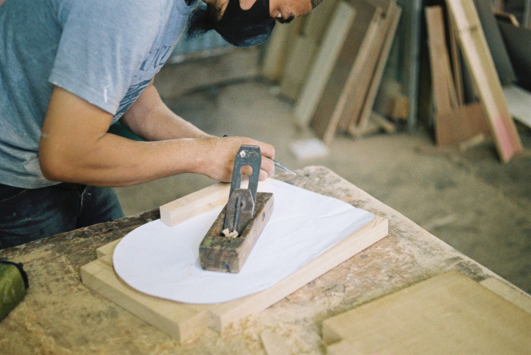 Ein Anriss wird mit Bleistift und Winkel auf ein Holzstück übertragen.
